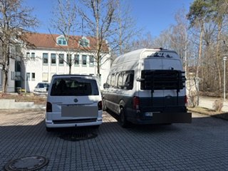 Zwei Vans auf einem Werkstatthof mit unkenntlichen Kennzeichen