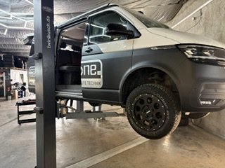 Volkswagen Van auf einer Hebebühne vor der Gear Carrier Montage